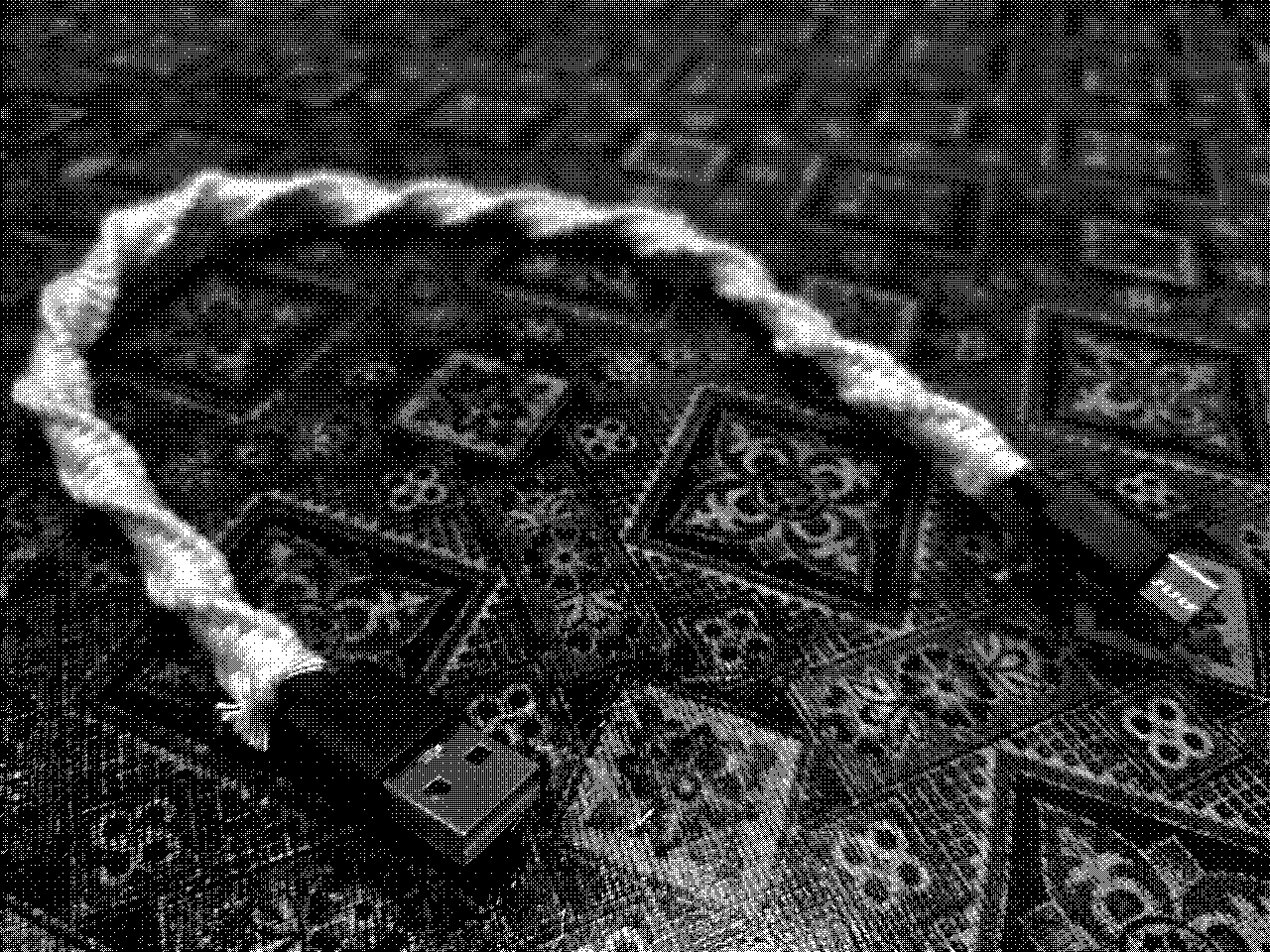 A USB cable lying on the table. The cable is wrapped in a white cord that is knotted using the macrame technique.